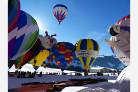 アルプスの雪景色に広がる国際熱気球フェス