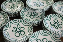 グリーンの渦がお皿やボウルの縁で踊るオーストリア伝統の陶器
